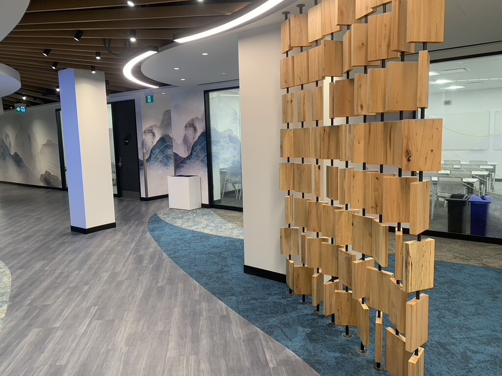 ILAC headquarters retrofit, 120 Bloor St E. — wood-block partition, mountain mural, curved wood-slat ceiling